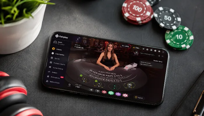 User viewing a live blackjack casino dashboard on smartphone with poker chips on desk